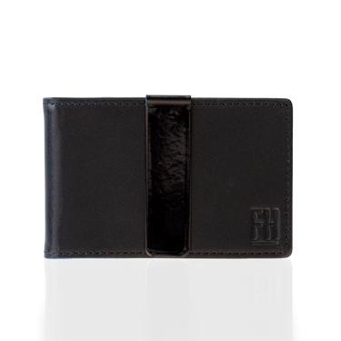 A black leather slim wallet with a black stainless steel money clip, displayed against a dark background.